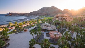 A resort with a beach view, palm trees, and a central courtyard with a circular building. - Two bedroom suite at Villa Del Palmar resort, Danzante Bay TPC golf course. (Ensenada)