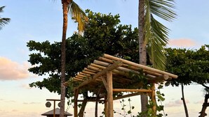 A wooden beach gazebo with a roof, surrounded by palm trees and a sandy beach. - MHV Milagres - Casa Naluum G4 (Passo de Camaragibe)