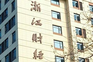 Un edificio de varios pisos con grandes ventanales y un letrero con caracteres chinos.