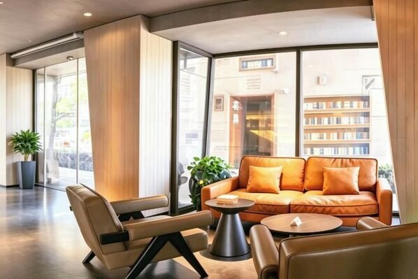 A modern lobby with a leather sofa, armchairs, and a coffee table.