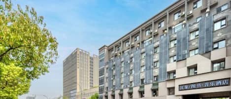 Un hotel de varios pisos con fachada moderna, que combina elementos de vidrio y metal.
