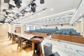 A conference room with a long table, chairs, and a stage area with a podium. - Hanxiang Hotel (Hangzhou Wenyi West Road Branch University of Finance and Economics) (Hangzhou)