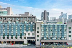 A modern hotel with a glass facade, multiple floors, and a prominent entrance. - Hanxiang Hotel (Hangzhou Wenyi West Road Branch University of Finance and Economics) (Hangzhou)