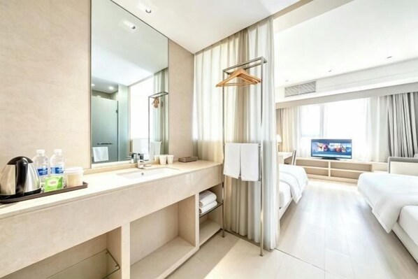 A hotel room with a large mirror, a sink, a television, a bed, and a window with curtains. - Hanxiang Hotel (Hangzhou Wenyi West Road Branch University of Finance and Economics) (Hangzhou)
