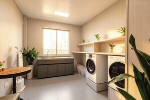 A compact kitchen with a washing machine, a sink, and a window.