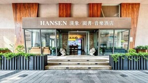 A hotel entrance with a sign reading 'HANSEN' and a modern design with wooden accents and glass doors. - Hanxiang Hotel (Hangzhou Wenyi West Road Branch University of Finance and Economics) (Hangzhou)