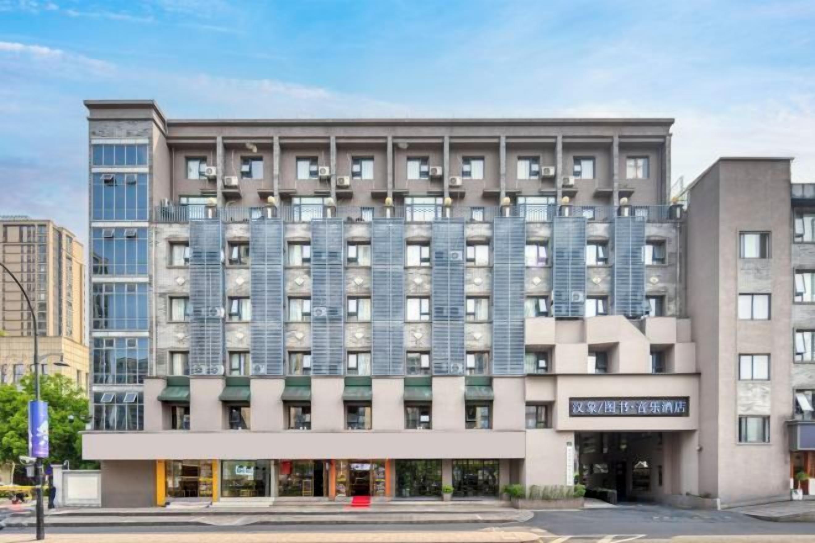 Un hotel de varios pisos con fachada moderna, amplias ventanas y una entrada destacada.