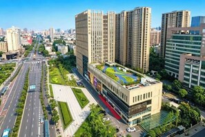 A high-rise building with multiple floors, surrounded by a well-maintained urban environment. - Hanxiang Hotel (Hangzhou Wenyi West Road Branch University of Finance and Economics) (Hangzhou)