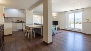En moderne lejlighed med køkken, spiseområde og en balkon med udsigt.