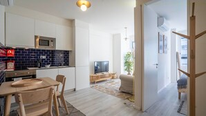 Ett modernt kök med mikrovågsugn, diskho och en matplats med bord och stolar.