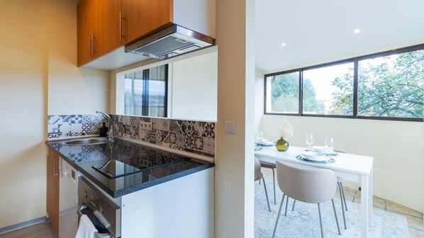 Enjoy meals in the kitchen with a sleek countertop and adjacent dining area featuring a table for four.