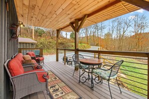 Um deck de madeira com móveis de exterior, uma mesa e cadeiras.