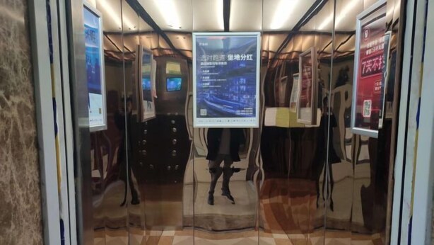 An elevator with digital displays and advertisements. - 7Days Inn Chain Hotel (Xuancheng High-Speed Railway Station) (Xuancheng)