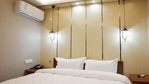 A hotel room with a bed, bedside tables, an air conditioning unit, and pendant lights. - 7Days Inn Chain Hotel (Xuancheng High-Speed Railway Station) (Xuancheng)