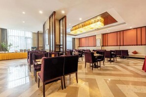A spacious hotel lobby with multiple seating areas, a reception desk, and a large window providing natural light. - Chang'an Baiyun Hotel (Beijing)