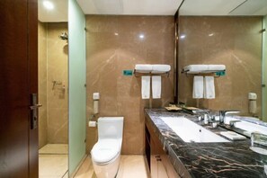 A modern bathroom with a marble vanity, a toilet, and a shower. - Chang'an Baiyun Hotel (Beijing)