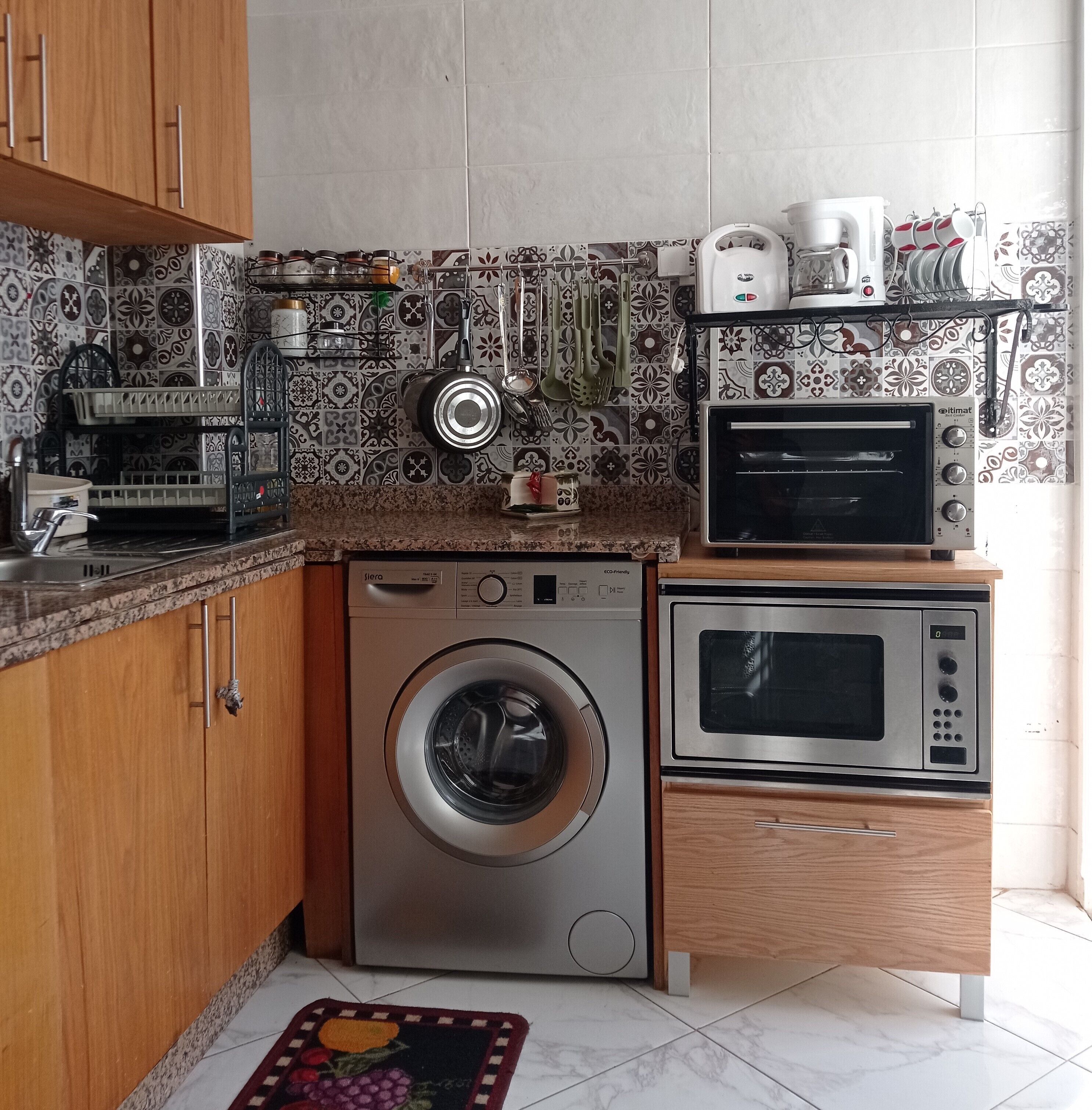 Cocina compacta con lavadora, microondas y tostadora.