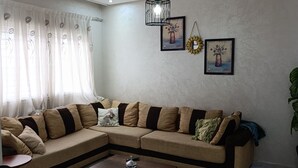 Ein Wohnzimmer mit Ecksofa, Couchtisch und einer Kronleuchter.