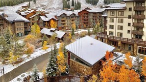 A resort with multiple buildings, a ski slope in the background, and a river in the foreground. - Amazing Copper Mountain Views! Steps to Lifts! (Frisco)