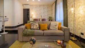 A modern living room with a sofa set, a glass coffee table, and a decorative globe. - Morgana Charming Apartment Close to Vatican (ROMA)