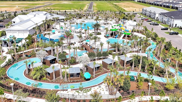 Ein Resort mit mehreren Swimmingpools, Wasserrutschen und Palmen.