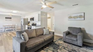 A modern living room with a sofa, armchair, and a ceiling fan. - Beautiful Apartment (Slidell)