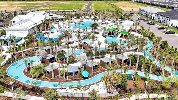 Un resort con varias piscinas, toboganes acuáticos y palmeras.