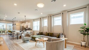 A spacious living area with a sofa, armchairs, a coffee table, and a dining table. - New beautiful 5 BEDS~Private Pool (Clermont)