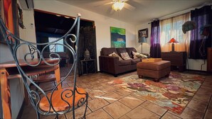 A living room with a brown sofa, a patterned rug, and a wooden coffee table. - Charming bungalow with an Amazing view of Sequoia National Park in Three Rivers. (Three Rivers)