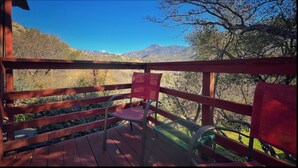 A wooden deck with a chair and a table, overlooking a mountainous landscape. - Charming bungalow with an Amazing view of Sequoia National Park in Three Rivers. (Three Rivers)