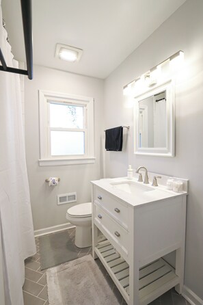 A bathroom with a white sink, mirror, and toilet. - Modern & Cozy Home - Minutes from NoDa & Uptown (Charlotte)