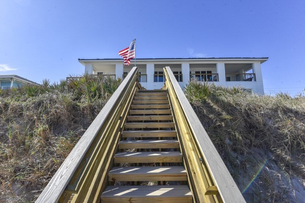 Un escalier en bois menant à un bâtiment sur lequel flotte un drapeau américain.