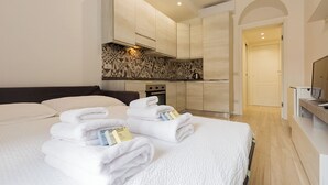 A hotel room with a bed, a TV, a kitchen area, and a bathroom. - Termopili29 Cozy apartment in NoLo by Hospity (Milano)