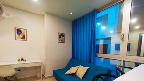 A room with a blue sofa, a white desk, and a bed. - a una cuadra de la playa  (Santa Marta)