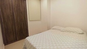 A bedroom with a bed, a wardrobe, and a window. - a una cuadra de la playa  (Santa Marta)