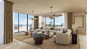 A spacious living room with a large sofa set, a coffee table, and a view of the beach. - Amoh, A Luxury Collection Resort, Rhodes (Rhodes)