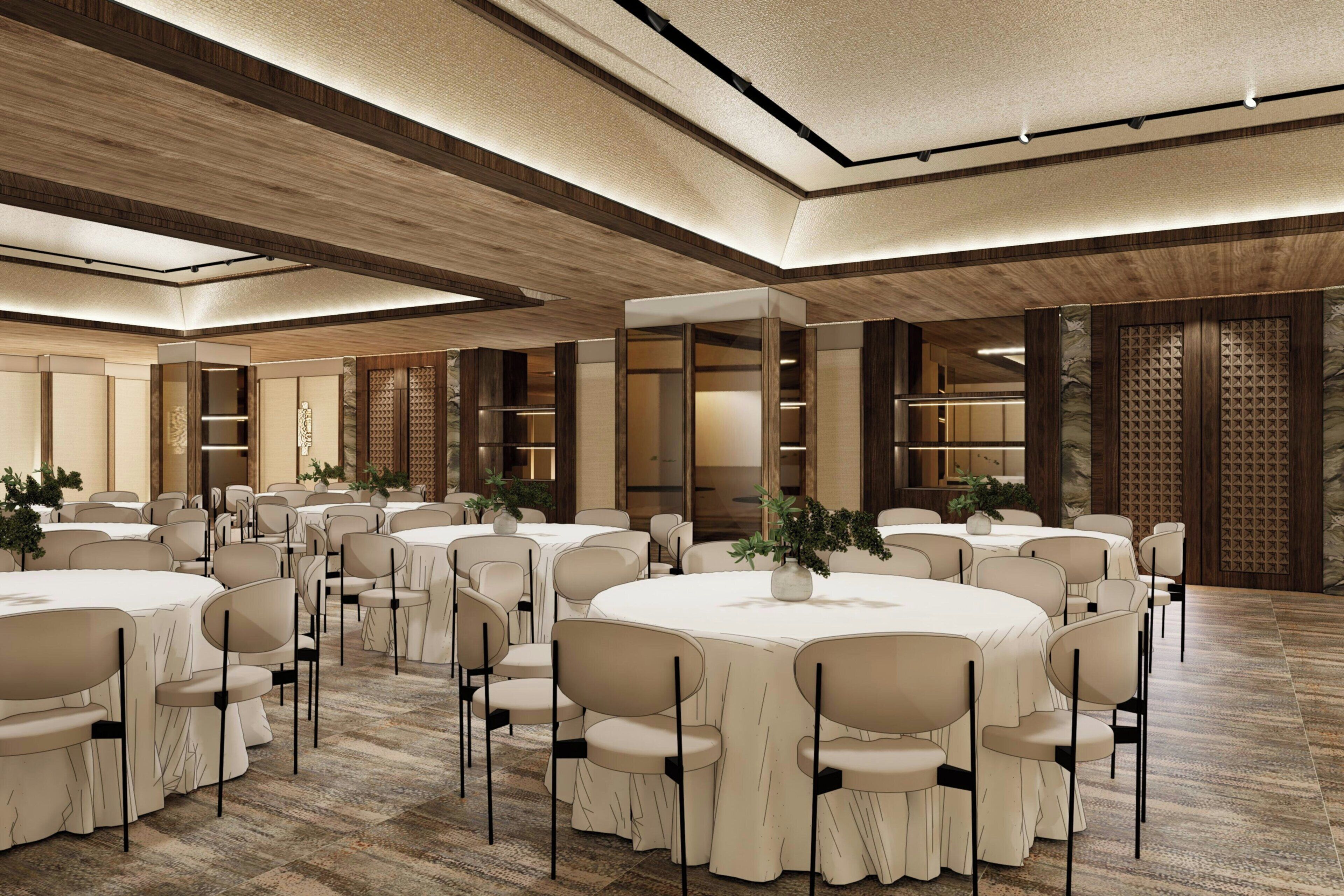 Une vaste salle de banquet dotée de tables et de chaises rondes, de lambris en bois aux murs et d’un plafond haut avec des luminaires encastrés.