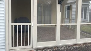 A covered porch with a screened door and a black lantern. - Spacious 7-bedroom house on quiet cul-de-sac in heart of Plattsburgh (Plattsburgh)