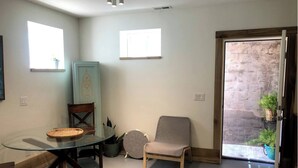 A dining area with a glass table, chairs, and a decorative cabinet.