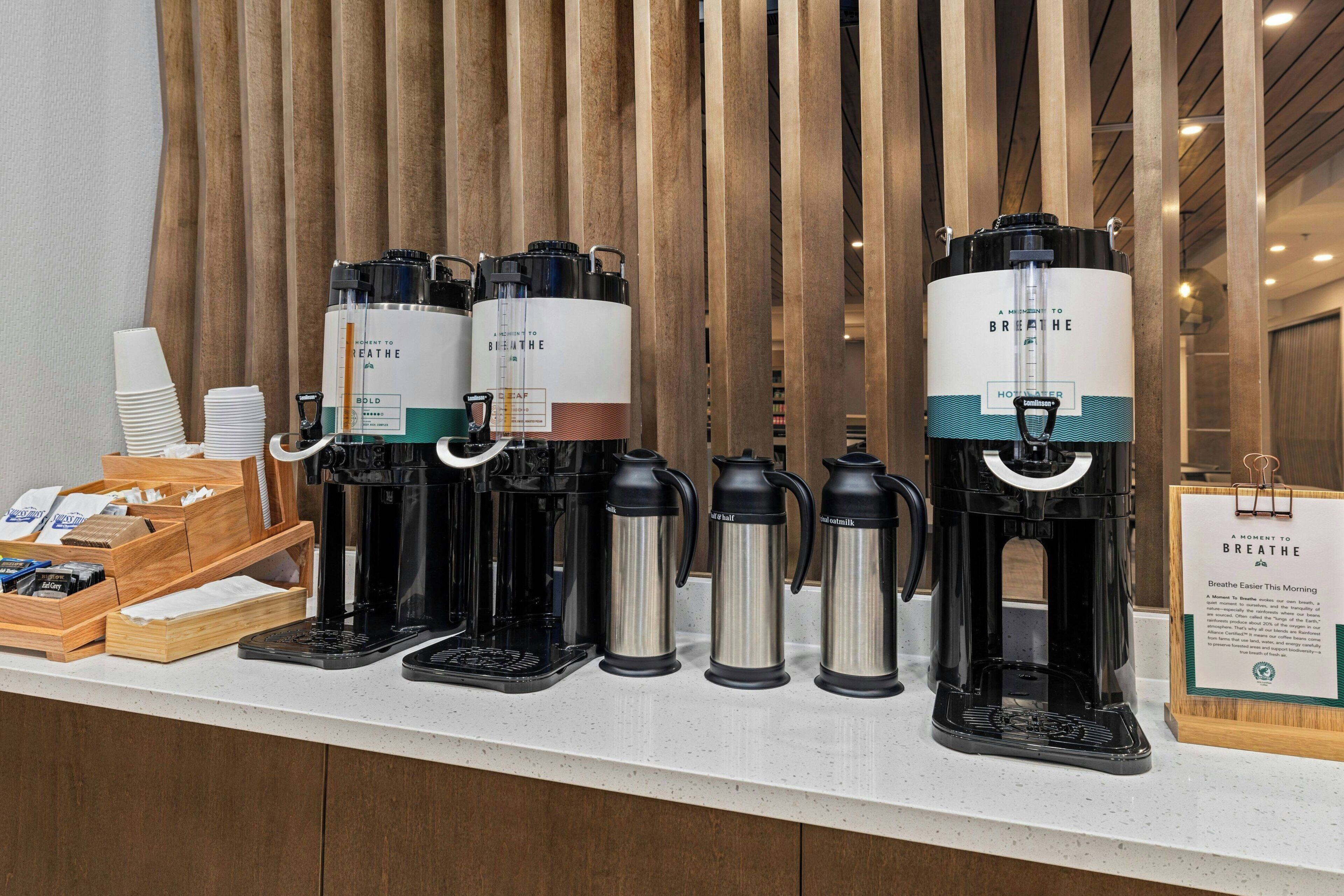Estação de café com várias máquinas de café e térmicas.