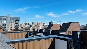 A rooftop with a view of a city skyline, featuring modern buildings and a clear blue sky. - Perfect getaway in Corktown! (Detroit)
