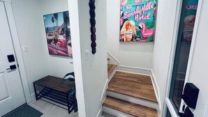 A staircase with wooden steps and a wall-mounted picture of 'The Beverly Hills Hotel'. - Perfect getaway in Corktown! (Detroit)