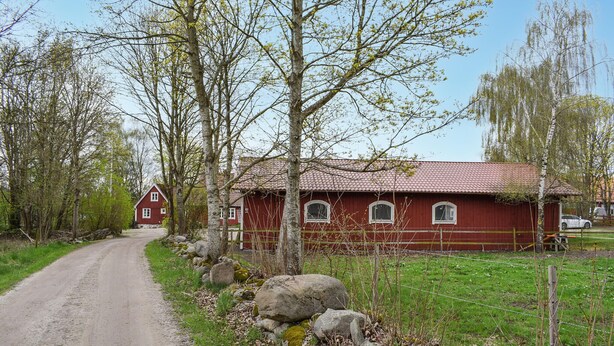A rural road leading to a red wooden house with a tiled roof, surrounded by trees and rocks. - Pet friendly apartment in Kristianstad (Kristianstad)