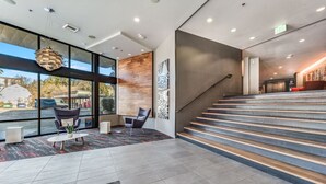 A modern lobby with a staircase, large windows, and seating area. - Spacious Modern 1BR 1BA w/ AC | Downtown Redmond (Redmond)