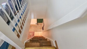 A staircase with wooden steps and white walls.