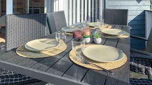 An outdoor dining table set with plates, cutlery, and glassware, surrounded by wicker chairs. - Stunning home in Frørup with WiFi (Frørup)