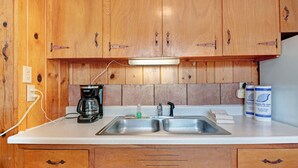 A kitchen with wooden cabinets, a double sink, a coffee maker, and a bottle of dish soap. - "B" Bear Cabin - South Fork (South Fork)