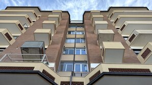 A multi-story building with a symmetrical facade, large windows, and a central staircase. - P051 – Porto Recanati, comfortable two-room apartment with sea view (Porto Recanati)