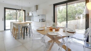Una cocina moderna con comedor, ventanas amplias y vistas al exterior.