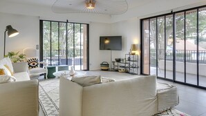 Una sala moderna con un sofá, una mesa de centro, una lámpara y un televisor.